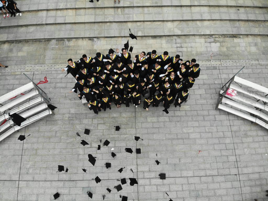 Studenti che lanciano i tocchi di laurea per il Project Work Pegaso